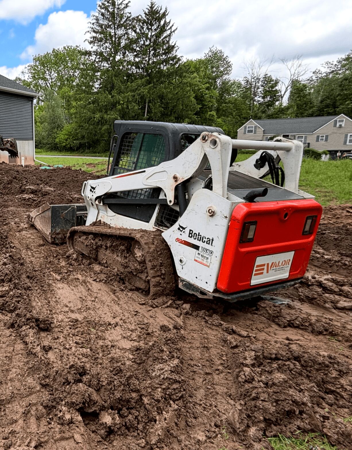 VALOR skid steer cutting a site to rough grade in Central New York